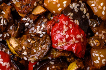 Delicious juicy fresh salad of baked eggplant, tomatoes, sweet peppers, sesame seeds