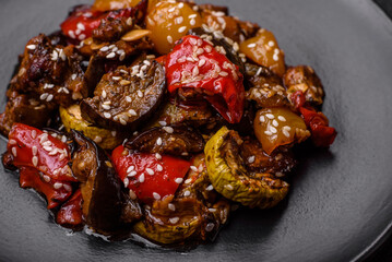 Delicious juicy fresh salad of baked eggplant, tomatoes, sweet peppers, sesame seeds