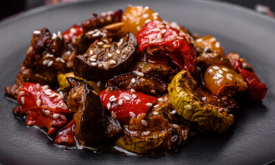 Delicious juicy fresh salad of baked eggplant, tomatoes, sweet peppers, sesame seeds