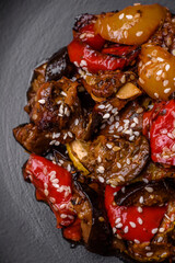 Delicious juicy fresh salad of baked eggplant, tomatoes, sweet peppers, sesame seeds