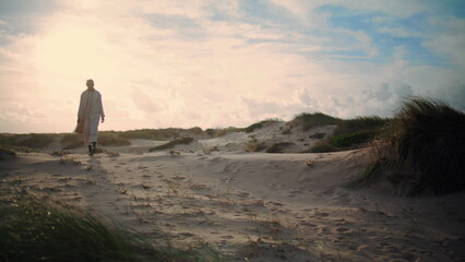 Serene woman walking sand dunes. Calm model silhouette enjoying seaside morning