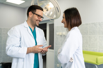 Two adult happy and cheerful medical professionals male and female doctors having discussion in...