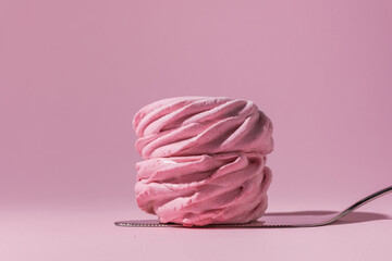 Macro shot of single pink berry homemade marshmallow on confectionery spatula. Zefir dessert with...