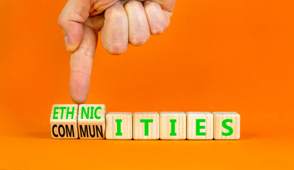 Ethnicities or communities symbol. Concept words Ethnicities and Communities on wooden cubes. Beautiful orange background. Businessman hand. Business ethnicities or communities concept. Copy space.
