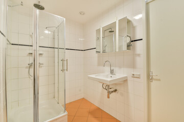 a bathroom with orange flooring and white tiles on the walls, along with a walk - in shower stall
