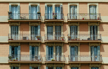 Fototapeta na wymiar Exterior of traditional residential house with balconies and wooden shutters on the windows in European city