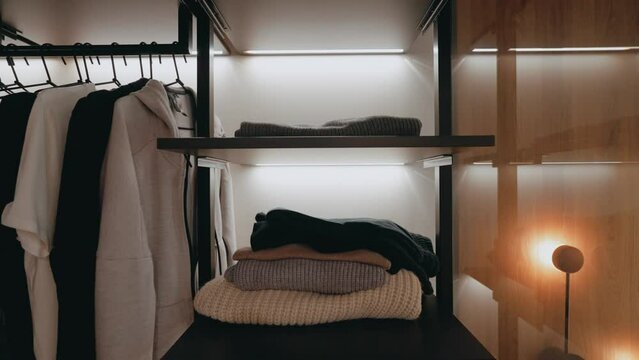 Luxury Bedroom With Walk In Closet. Dressing room with things. Elegant Wooden Built Walk In Closet Decoration. Luxury Dressing Room With Closet. Black wardrobe with classic shirt.