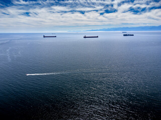 Aerial freighters anchored off Vancouver Island overlooking the Olympic Peninsula in Washington State in Victoria British Columbia Canada.