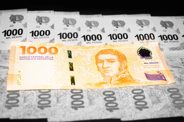 New bill of 1000 Argentine pesos over previous bills of one thousand pesos, San Martin bill, Argentine money, Argentine currency, Argentine pesos. black and white background