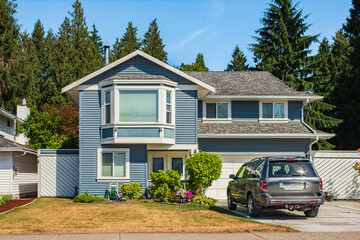 Contemporary house exterior in Vancouver Canada. Big modern house with beautiful landscaping and driveway to garage