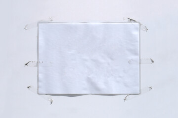 Blank white paper sign roughly stuck with dirty adhesive tape on white door, text mockup template, copy space