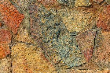 Multi-colored facade of the building wall is made of natural stone, a bit like granite and marble....