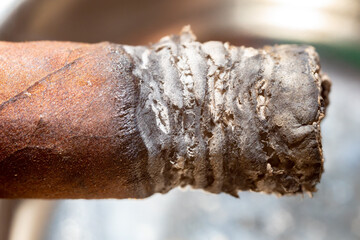 Traditional Cuban cigar with ash macro detail