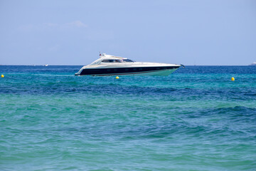 Crystal clear blue water and boats on legendary Pampelonne beach near Saint-Tropez, summer vacation on white sandy beach of French Riviera, France