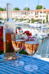 Pouring in glasses of cold rose Cote de Provence wine in yacht harbour of Port Grimaud, summer vacation on French Riviera Provence, France