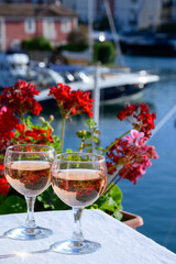 Pouring in glasses of cold rose Cote de Provence wine in yacht harbour of Port Grimaud, summer vacation on French Riviera Provence, France