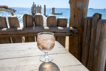 Summer time in Provence, glass of rose wine with ice cubes on bar terrace Pampelonne sandy beach...