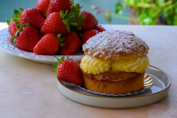 Tarte tropezienne or La Tarte de Saint-Tropez - dessert pastry consisting of filled brioche with cream and fresh berries served outdoor with fresh ripe strawberry