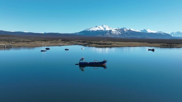 Boat Sailing At Puerto Natales In Ultima Esperanza Chile. Snowy Mountains. Bay Water Landscape. Ultima Esperanza Chile. River Background. Boat Sailing At Puerto Natales In Ultima Esperanza Chile.