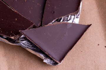 A broken chocolate bar in a paper and foil package