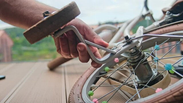 Caucasian Male Father Installing Stabilizing Training Side Wheels on Child Bike for Easier Learning