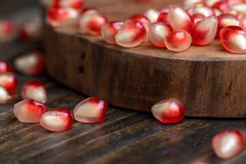 Red pomegranate seeds on the table and the board
