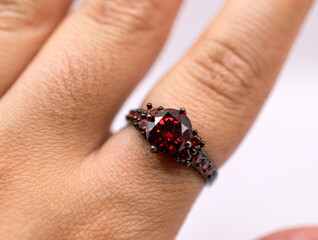 red ruby ring on a finger 