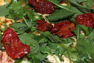 details of arugula pizza with dried tomatoes. pizza texture. Italian food. food details.