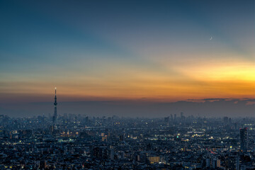 Fototapeta na wymiar Cityscape of greater Tokyo area with crescent moon at magic hour.
