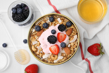 Tasty granola, yogurt and fresh berries served on white tiled table, flat lay. Healthy breakfast