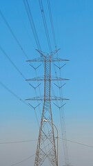 Clear Sky and Electrical Transmission Tower Against a Blue Background