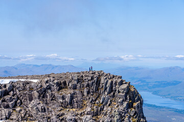 Two People Standing on a Rocky Outcropping Near the Summit of Ben Nevis in Scotland United Kingdom