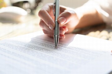 Businesswoman's Hand Signing Contract With Pen