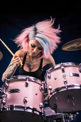 A drummer girl with pink hair playing pink drums
