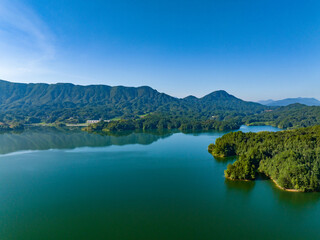 Fototapeta na wymiar Aerial photography of a large reservoir with blue sky and white clouds and mountains