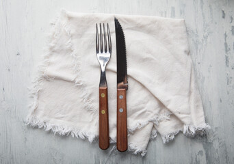 Fork and knive on a white background over a white cloth napkin