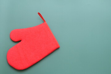 red wool winter glove on green background, christmas decoration