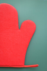 red wool winter glove on green background, christmas decoration