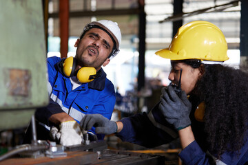 male worker or engineer have been injured in an accident from working on machine and coworker try...