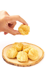 Hand Holding Cream puffs (Choux cream or Eclair) isolated on white background. Cream puffs are made with a light choux pastry that puffs up when baked. filled with vanilla cream.
