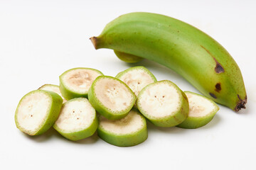 Group of unripe bananas (green) isolated on white background, unripe bananas are versatile and high in fiber. Top view of sliced banana inside, seeds and green banana peel.