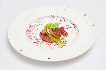 Foie gras and smoked duck breast with mixed berry sauce in white dish isolated on white background.