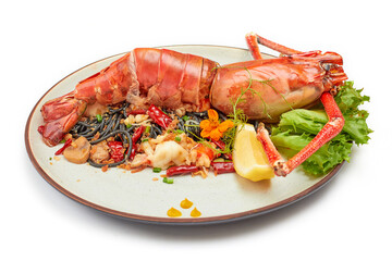 Black pasta stir fried chili with river prawn (Big size) on porcelain plate isolated on white background. The black color of the pasta is caused by the pasta mixed with the black ink of the squid.