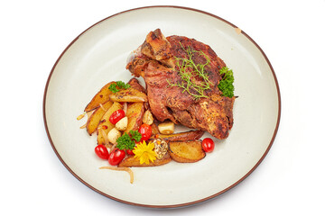 Top view of Roasted pork leg with paprika powder and garlic roasted potatoes on porcelain plate isolated on white background.