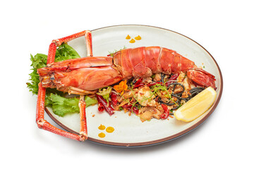 Black pasta stir fried chili with river prawn (Big size) on porcelain plate isolated on white background. The black color of the pasta is caused by the pasta mixed with the black ink of the squid.