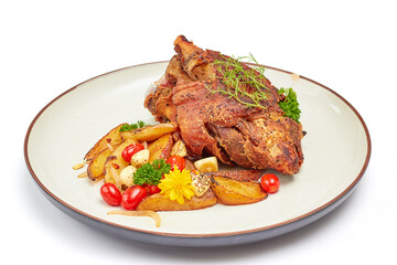 Roasted pork leg with paprika powder and garlic roasted potatoes on porcelain plate isolated on white background.