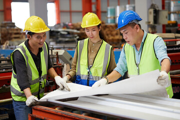 factory workers or engineers planning from work on blueprint drawing paper in the factory