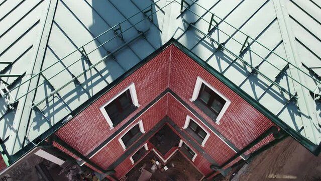 Construction and renovation of public building. Rooftop of red bricked structure on construction site. Process of erection of building