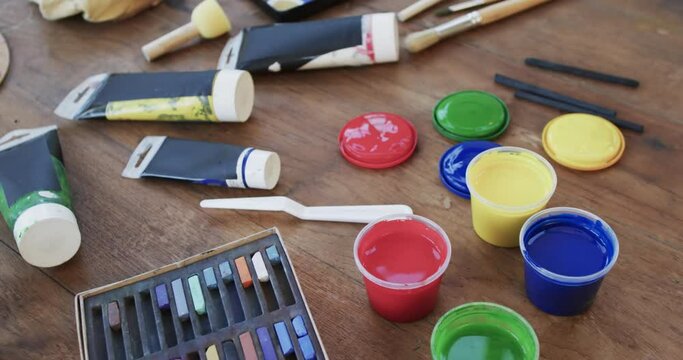 Close up of paints and brushes on table in studio, slow motion