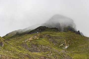 Dark Dramatic Desert Landscape with Foggy Mountains and Distant Houses in Muktinath, Mustang, Nepal